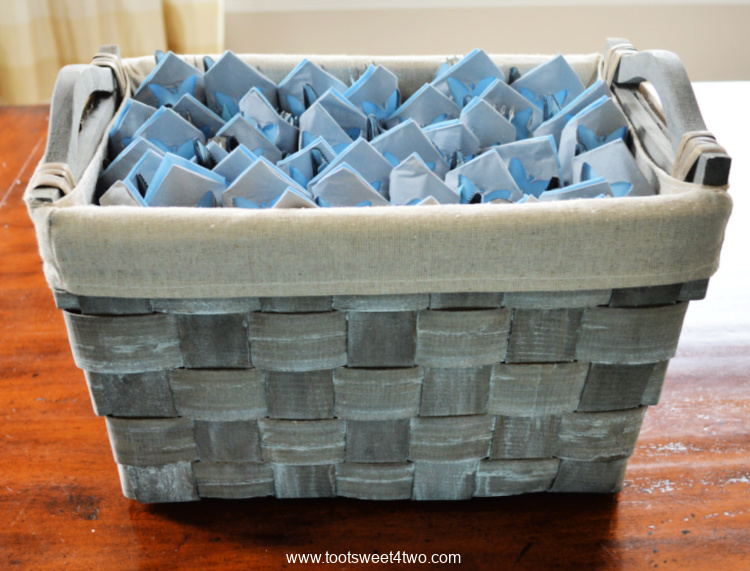 gray and blue napkins folded with utensils in a gray basket