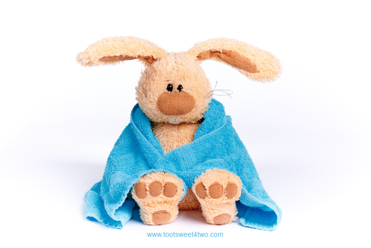 cute stuffed bunny wrapped in a blue towel