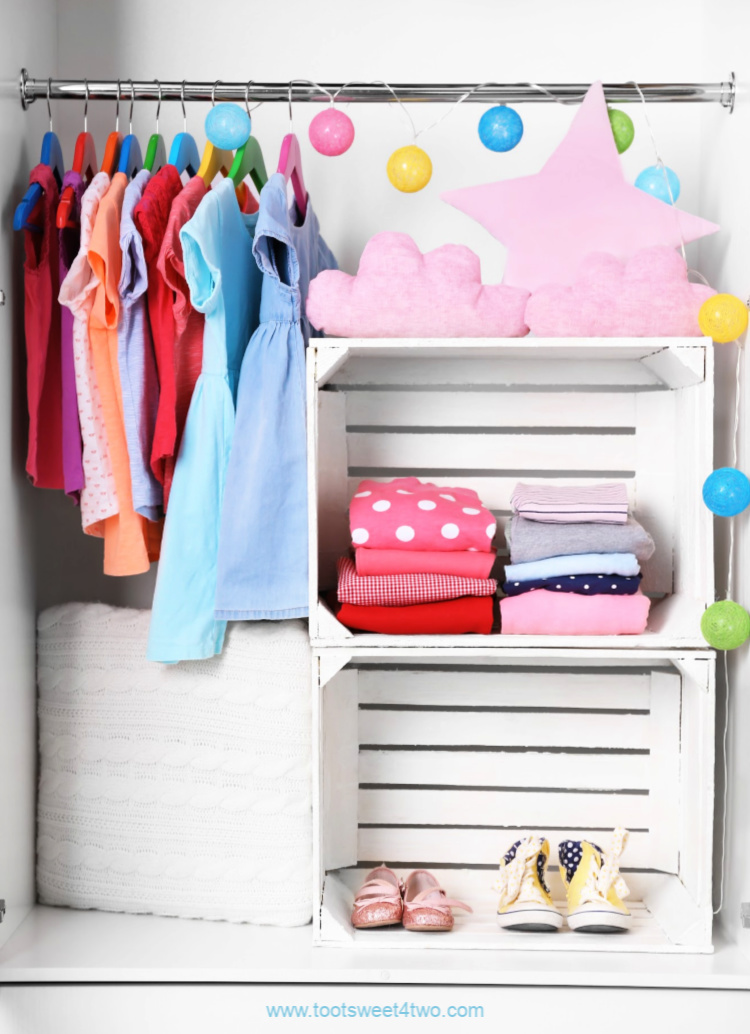 little girl's clothes closet with white crate shelves