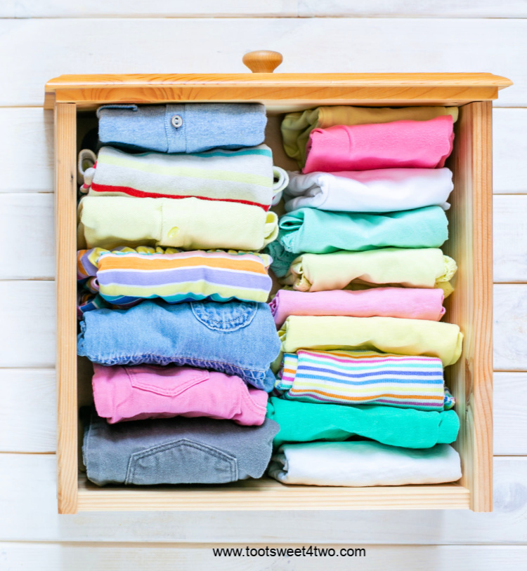 Neatly folded colorful children's clothes in drawer