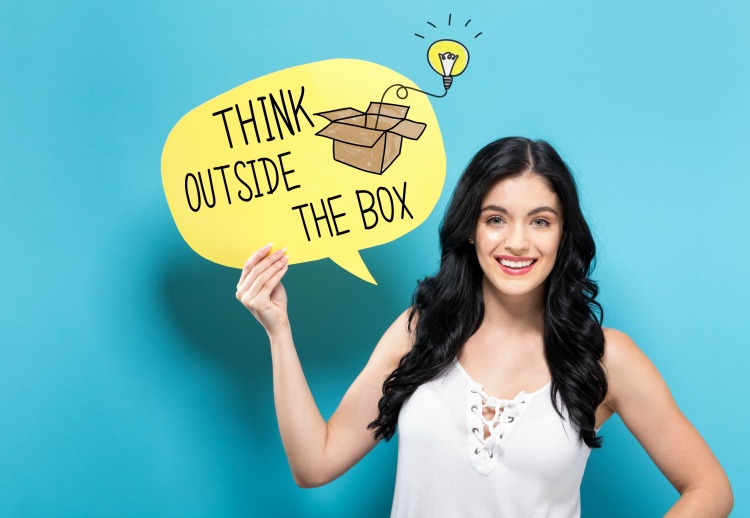 Think Outside The Box with young woman holding a speech bubble