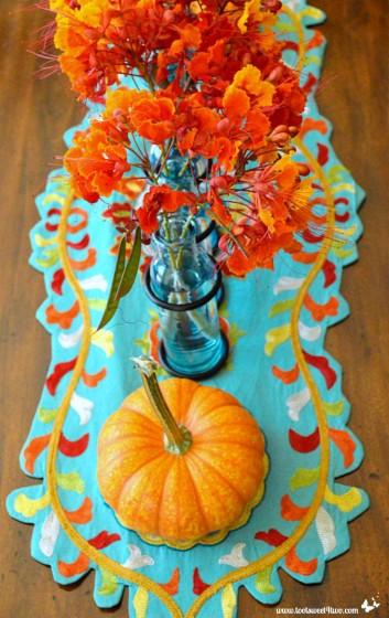 Turquoise table runner with mini pumpkin and Red Mexican Bird of Paradise