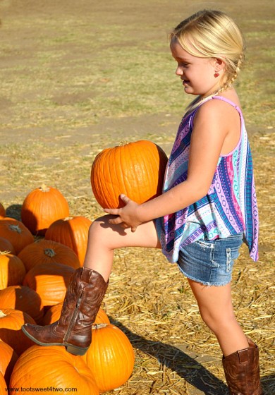 Princess Sweetie Pie hoisting a pumpkin on her knee