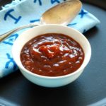 barbecue sauce in a small white bowl with a blue Western napkin