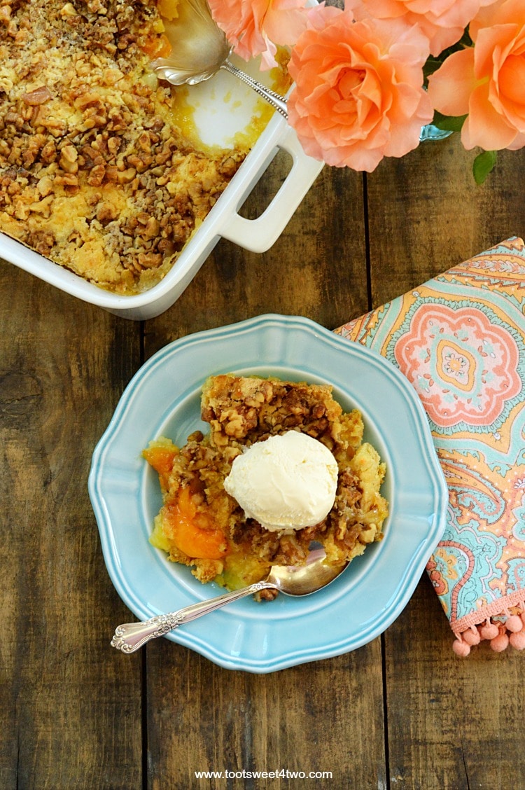 Peach Pineapple Dump Cake with Walnuts in a baking pan and on a blue plate