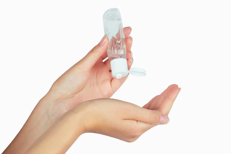 bottle with antibacterial antiseptic gel in hand on white isolate.