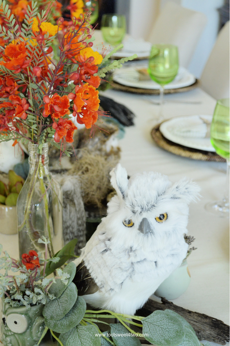green goblets and owl table decor on a dining table